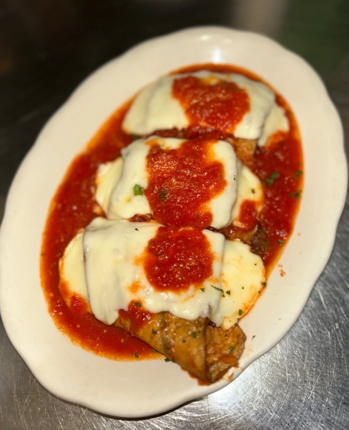 Eggplant rollatini covered in mozzarella and tomato sauce.